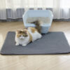tapis chat litiÃ¨re - chat brun et blanc allongÃ© sur le tapis de litiÃ¨re gris